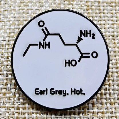 Earl Grey Hot enamel pin featuring chemical structure design on a white background.