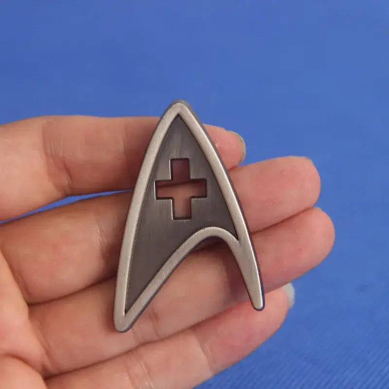 ST-Star X Trek Enamel Pin held in hand, stylish lapel pin for backpacks and jackets.